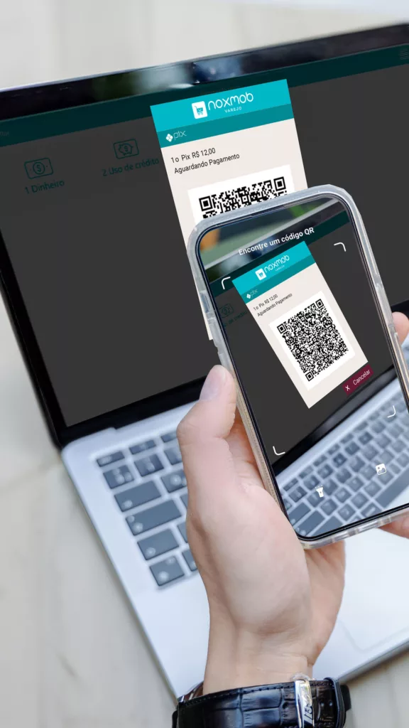 QR Code mostrado em uma tela de notebook e sendo escaneado por uma câmera de smartphone.