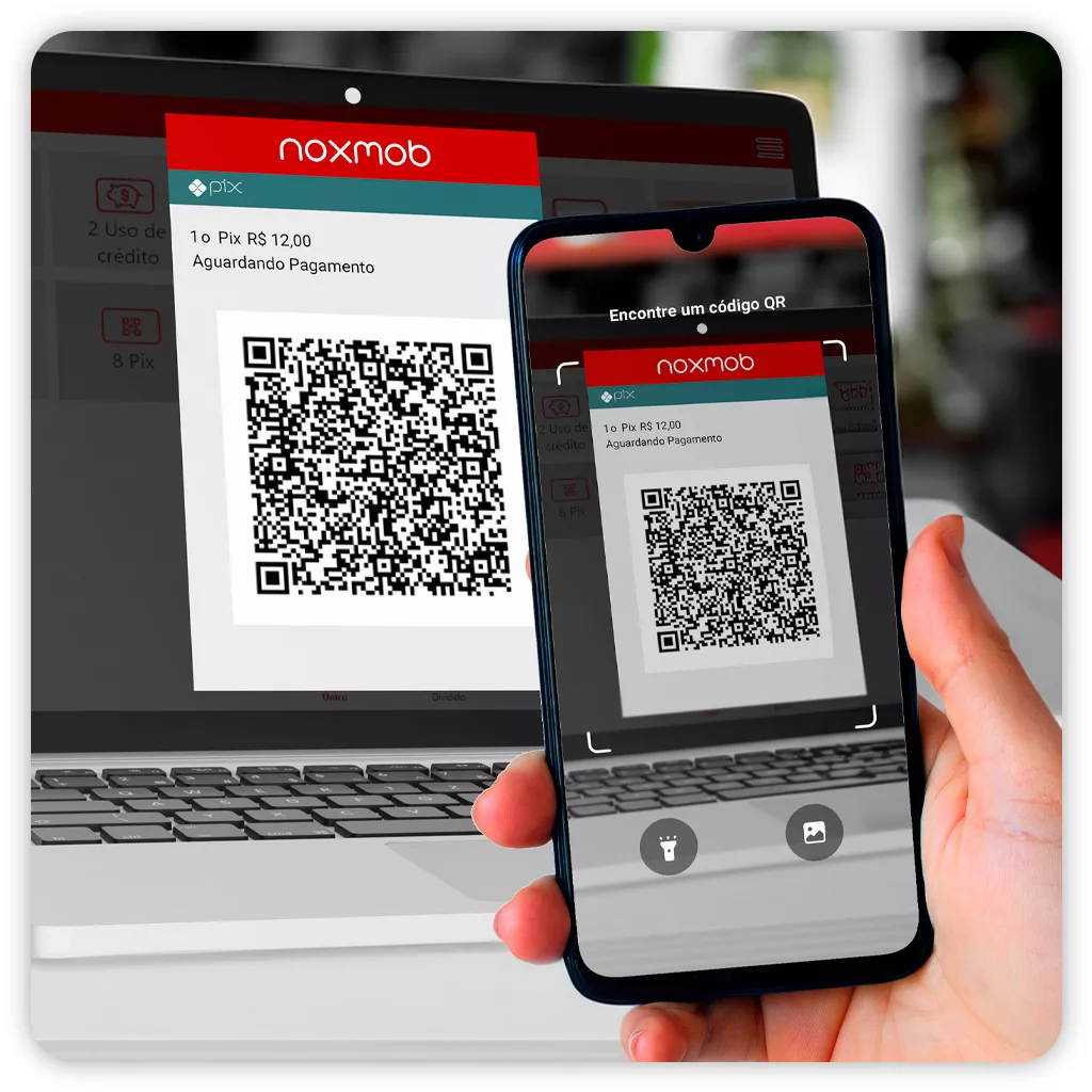 Um QR Code sendo mostrado na tela de um notebook e escaneado por uma pessoa utilizando smartphone.
